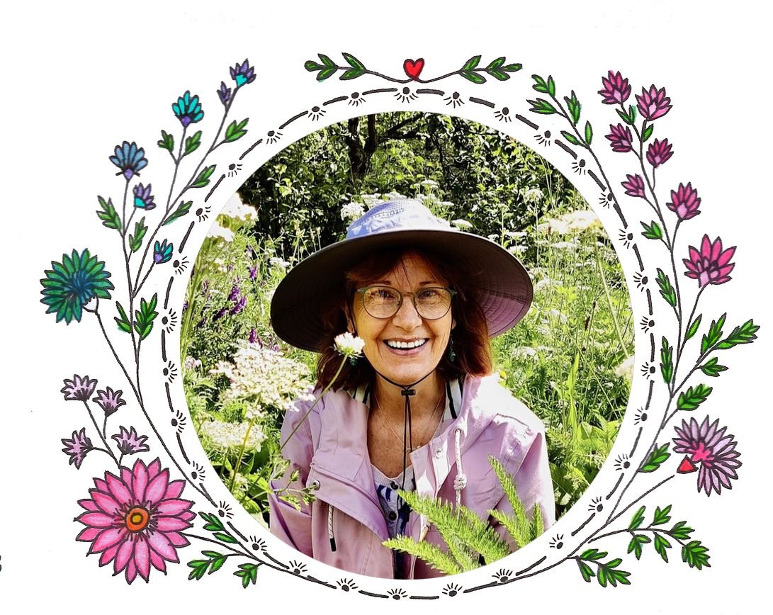 Nicky smiling in a sun hat, surrounded by the flowers of her garden